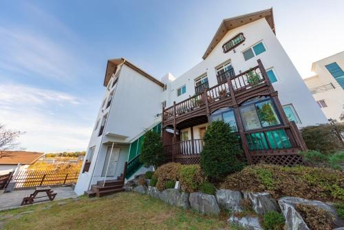 a large white building with a fence in front of it at Gyeongju Insta Spa Pension Spa, Individual BBQ in Gyeongju