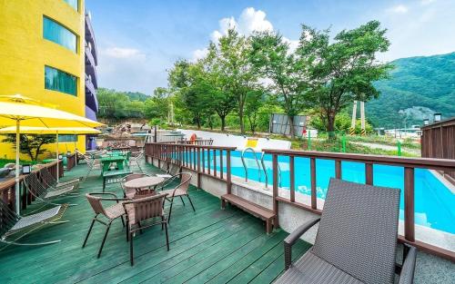 a balcony with tables and chairs and a swimming pool at Inje Tourist Hotel in Wŏrhang-ni