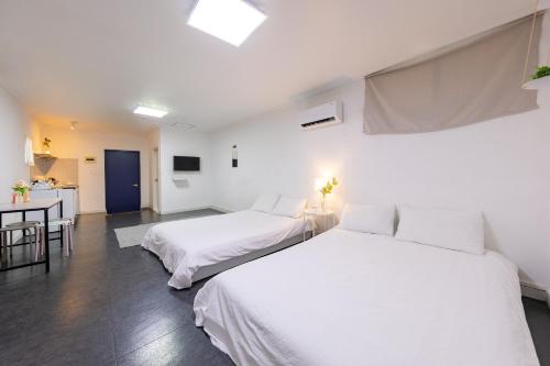 a bedroom with two beds and a kitchen at Goseong Oneul Bada Pension in Goseong
