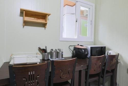 a room with a table with chairs and a microwave at Gangwon Mountain Bnb in Wonju