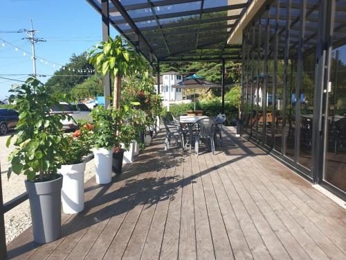 a patio with potted plants and a table and chairs at Gosung Shine House in Goseong
