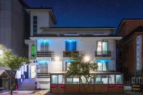 a white building with blue lights on it at Daecheon gyeoulyeonga pension in Boryeong