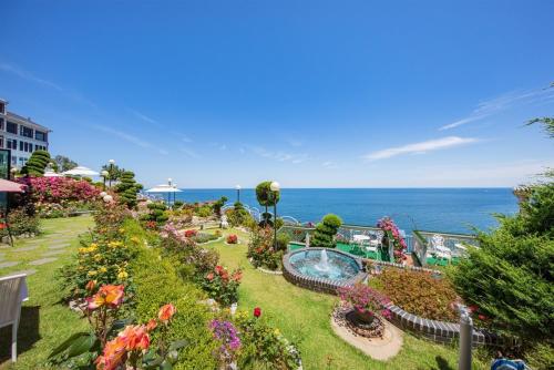 a garden with flowers and the ocean in the background at samceog ssienbeulrupensyeon in Samcheok