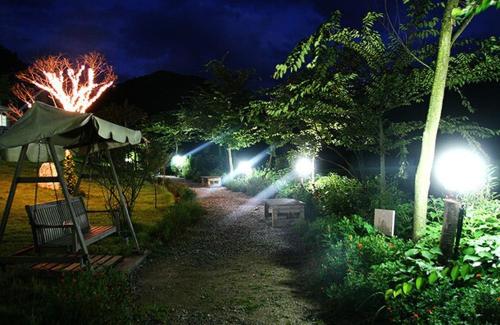 a garden at night with lights in the yard at Anmyeondo Lake Park Pension in Ch'anggi-ri