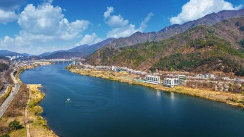 an aerial view of a river with mountains in the background at Gapyeong River Wave Pool Villa in Gapyeong
