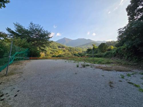 a soccer net on a gravel road with mountains in the background at Dolmadang Cheongsu Pension in Mungyeong