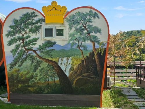 a mural of a painting of a tree with a crown at Hana Soop Gwangwang Nongwon in Seocheon