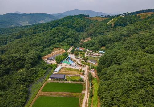 an aerial view of a farm in the middle of a mountain at Hana Soop Gwangwang Nongwon in Seocheon