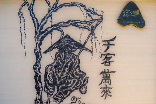 a drawing of a person hanging on a wall at Kim Satgat Heukjib Yiyagi in Yeongwol
