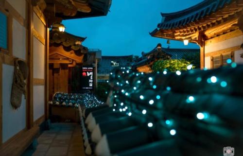 una fila de asientos en un balcón por la noche en Jeonju Byeoljari Hanok Pension, en Jeonju