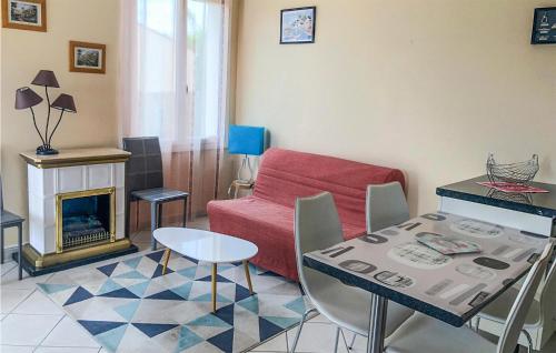 un salon avec un canapé rouge et une table dans l'établissement Gorgeous Home In La Faute Sur Mer, à La Faute-sur-Mer