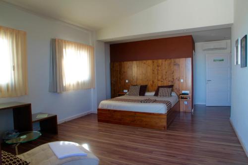 a bedroom with a bed with a wooden headboard at Hotel Mas Prades in Deltebre