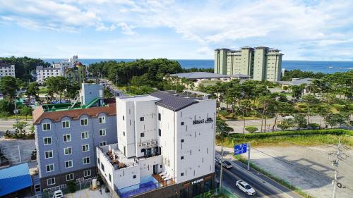 an aerial view of a white building in a city at Gangneung Nishi Spa Pension in Kyŏngp'o-mal