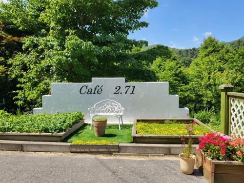 a sign for a garden with plants and a bench at Gapyeong House 2 71 Pension in Kŏjŏbi