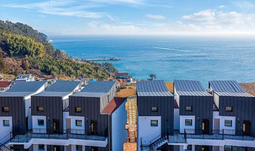 a group of buildings with solar panels on them next to the ocean at Stonecove Pension in Geoje 