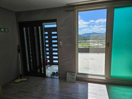 a room with a large glass door with a view at Yeosu Art Village 705 Pension in Hagŭm