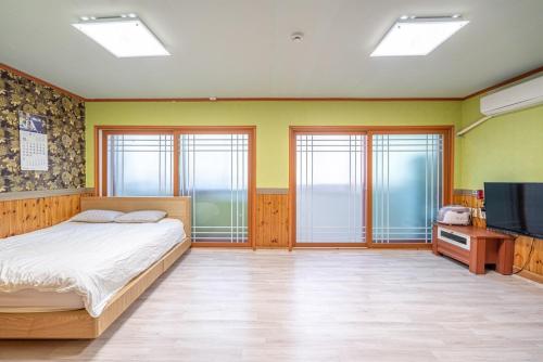 a bedroom with a bed and a flat screen tv at Trust Pension Taean in Taean