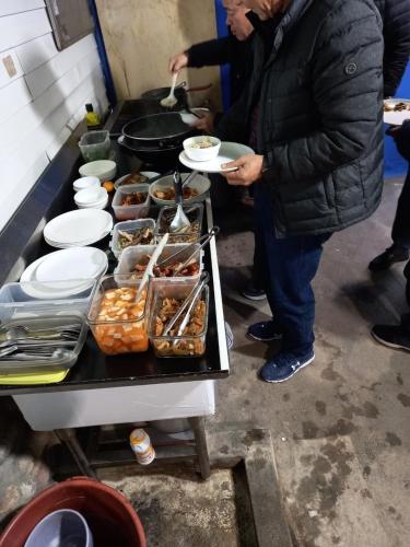 a man holding a plate of food on a table at Trust Pension Taean in Taean