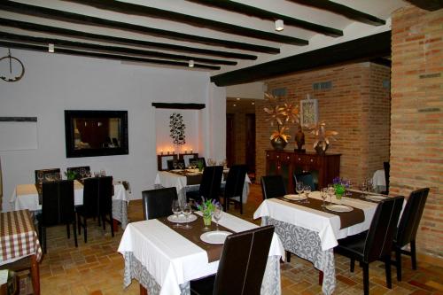 a restaurant with white tables and black chairs at Hotel Mas Prades in Deltebre