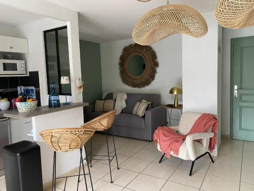 un salon avec un canapé et deux chaises dans l'établissement Bikini, an apartment near the square, à Cavalaire-sur-Mer
