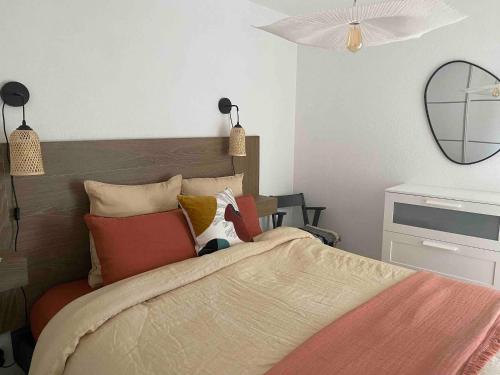 - une chambre avec un lit doté d'oreillers et d'un miroir dans l'établissement Bikini, an apartment near the square, à Cavalaire-sur-Mer