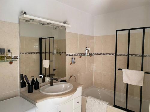 une salle de bain avec un lavabo et une baignoire dans l'établissement Bikini, an apartment near the square, à Cavalaire-sur-Mer