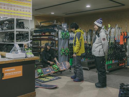 a group of people standing in a store with a skateboard at Chalet Shiga in Yamanouchi