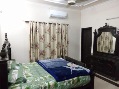 a bedroom with a bed and a dresser and a mirror at Couples not allowed - Beautiful 10 marla Portion only for Families near Talwar Chouk in Lahore