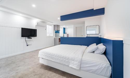 a white and blue bedroom with a bed and a tv at Gyeongju Dear Forma Pension in Gyeongju