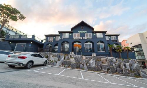 a blue house with a car parked in front of it at Gyeongju Dear Forma Pension in Gyeongju