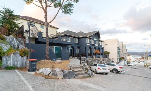 a large blue house with cars parked in a parking lot at Gyeongju Dear Forma Pension in Gyeongju