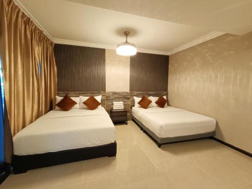 a bedroom with two beds and a light fixture at Tc theme park Guest house in Kuantan