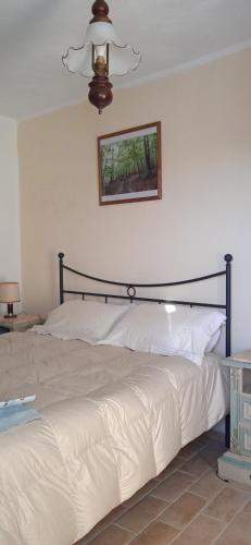 a bed in a bedroom with a picture on the wall at La dimora del castagno in Ormea