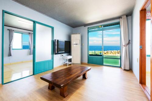 a room with a wooden table and a view of the ocean at Yeongdeok Stay 693 in Yeongdeok