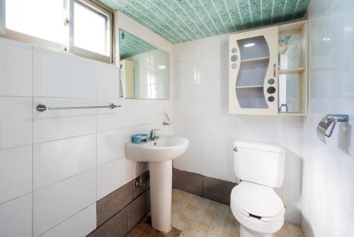 a white bathroom with a toilet and a sink at Yeongdeok Stay 693 in Yeongdeok