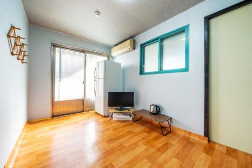 a living room with a television and a wooden floor at Yeongdeok Stay 693 in Yeongdeok