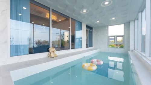 a teddy bear sitting on the edge of a swimming pool at Pohang Bahari Pool Villa in Pohang