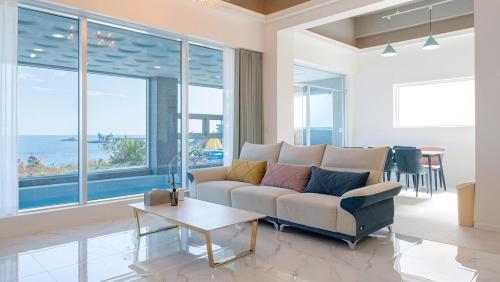 a living room with a couch and a table at Pohang Bahari Pool Villa in Pohang