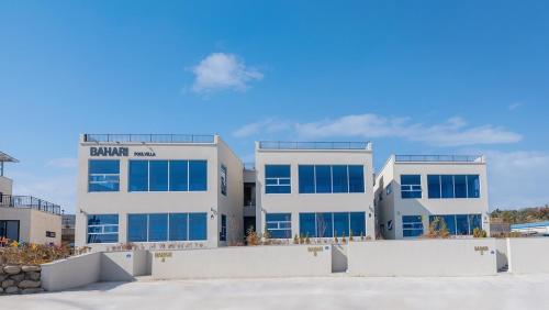 a large white building with blue windows at Pohang Bahari Pool Villa in Pohang