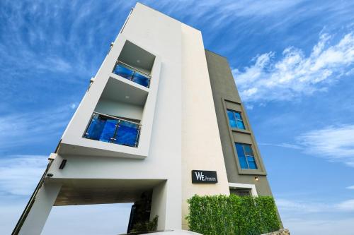 un edificio blanco con ventanas azules contra un cielo azul en Gangneung wi Pension, en Gangneung