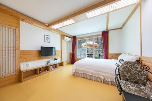 a bedroom with a bed and a tv at Chuncheon inyeonga pension in Wikkŏndŭrae