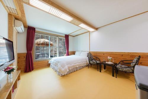 a bedroom with a bed and a window at Chuncheon inyeonga pension in Wikkŏndŭrae
