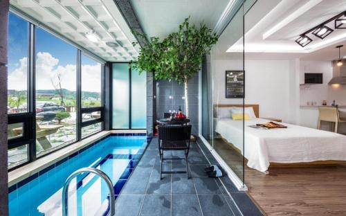 a bedroom with a pool and a bed and a room with a bed at Gyeongju Dia Pool Villa Pension in Gyeongju