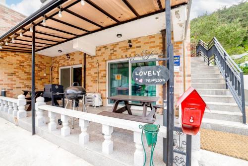 a building with a bench and a table on a porch at Lovely Pension in Inje