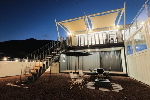 a house with an umbrella and a table and chairs at Stay the zion in Miryang