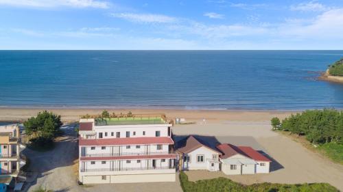 an aerial view of a house and the beach at Anmyeondo Badatga Pension in Chŏkkae