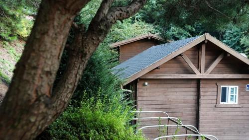 a small wooden building with a gambrel roof at Sobaeksan Log Pension in Ŭmji
