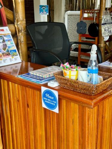 a ticket counter with two baskets and a bottle of water at Nay Carmen Pension House Port Barton in Itaytay