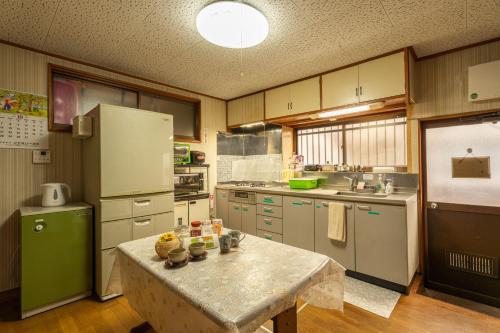 cocina con mesa y nevera verde en Asahi, en Fujiyoshida