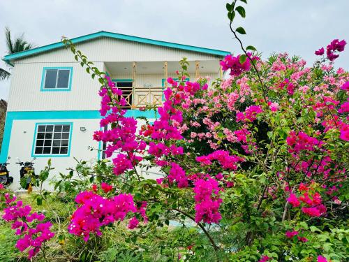 a house with pink flowers in front of it at Colorful Garden House in Providencia